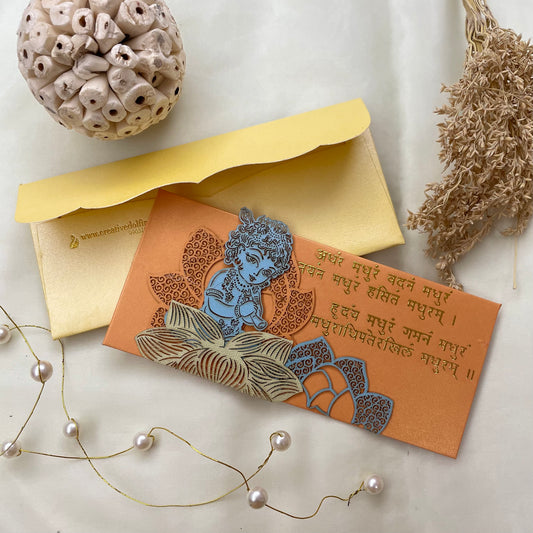 Yellow envelope with a laser patchwork design featuring an image of Krishna and mantras