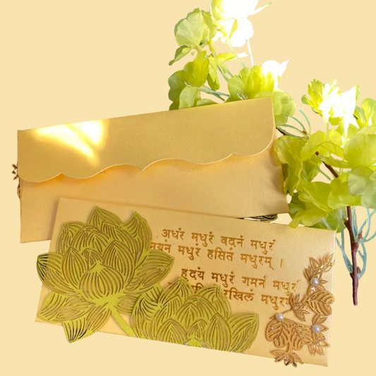 A decorative envelope with laser patchwork in green and gold colors, featuring floral designs and mantra in gold foil.