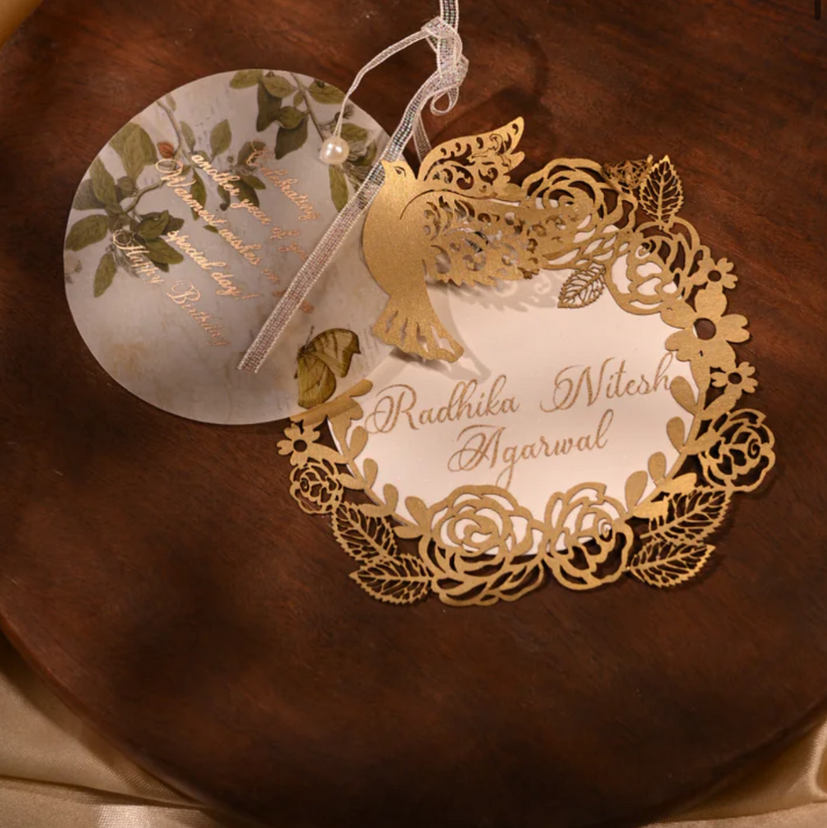 A decorative wedding favor tag with a gold floral lace border and a white center card