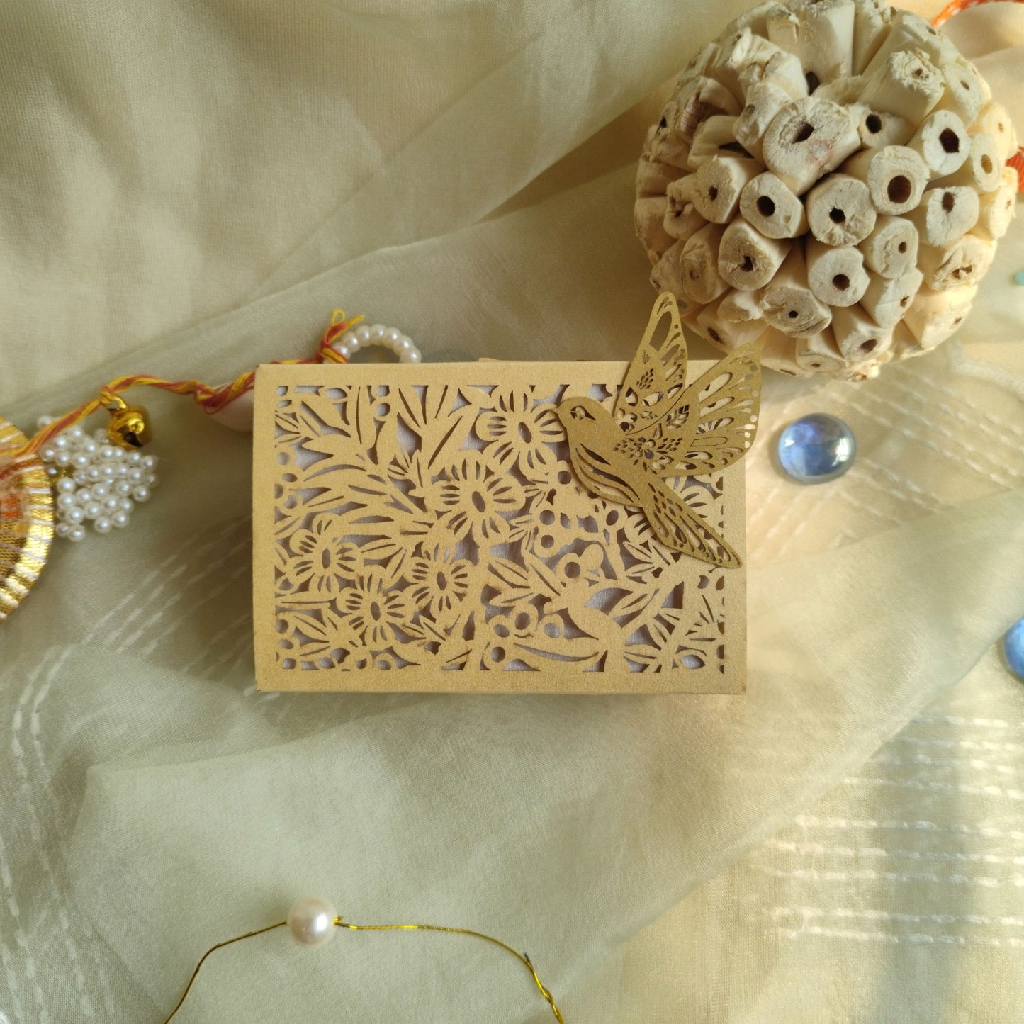 cream colour full jali coin box with intricately laser-cut floral patterns and a bird
