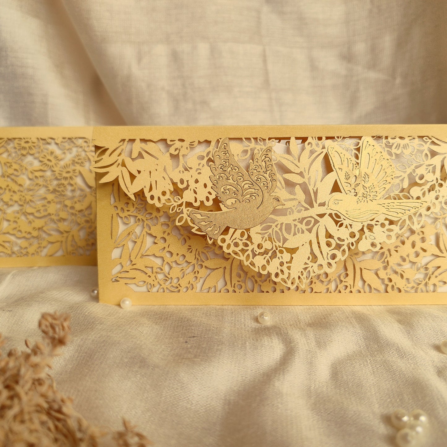 Decorative gold Envelope with intricate cut-out designs on a golden metallic paper. Pair of birds pasted on its flap.