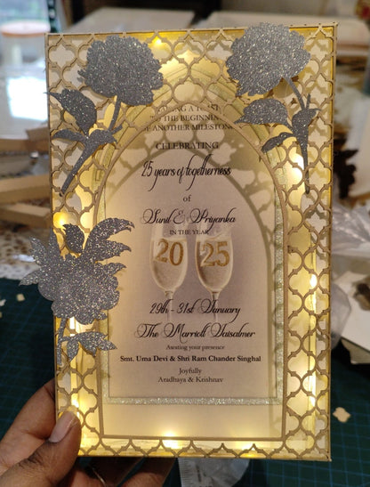 Decorative gold and silver invitation card with floral designs and text.