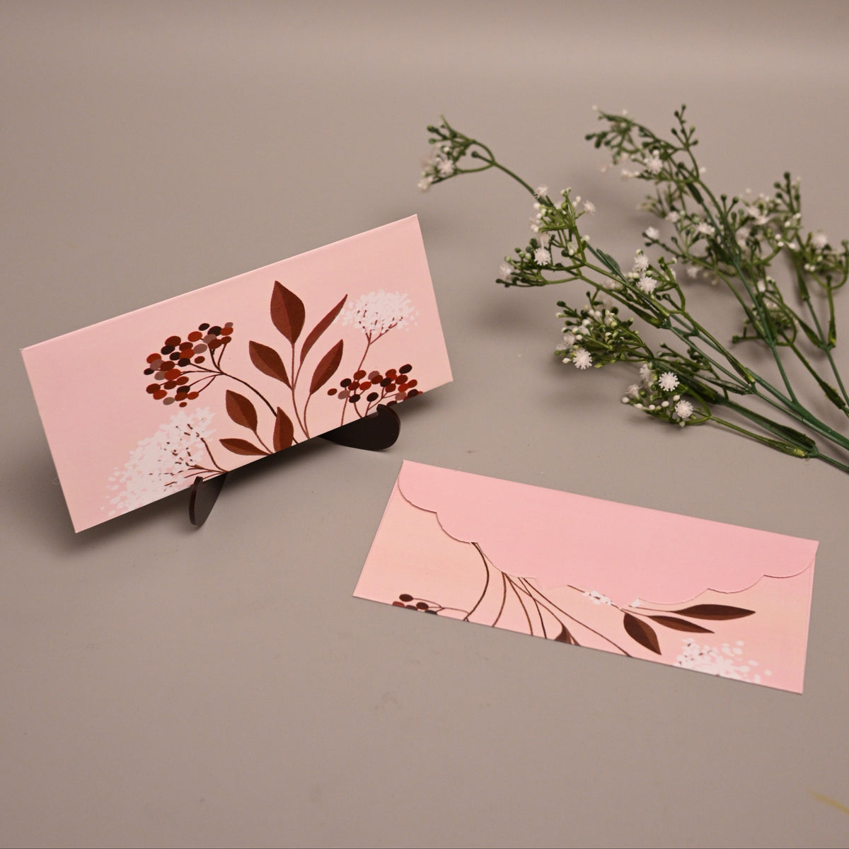 Printed Envelope with botanical illustrations, displayed on a neutral taupe background with baby's breath flowers.