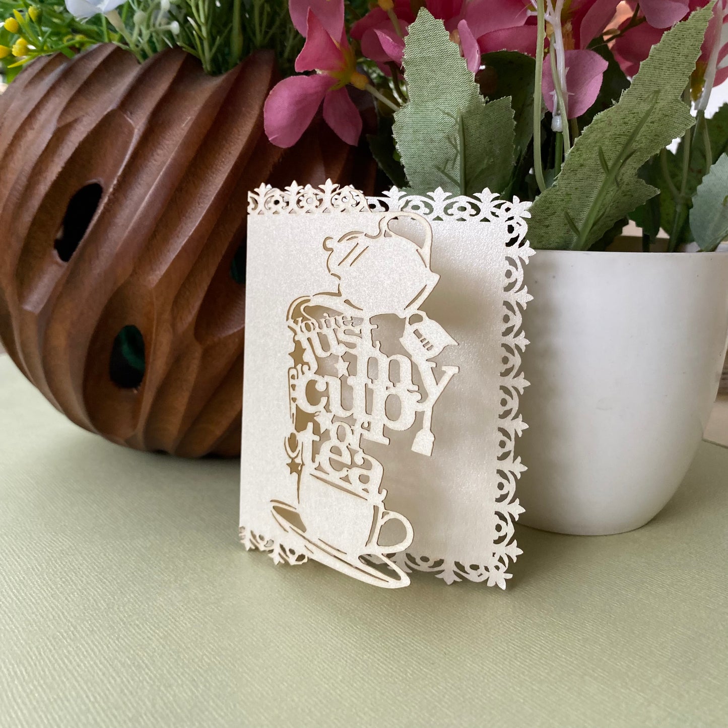 Decorative white gift tags with laser-cutwork, featuring a teapot, teacup and saucer, writing