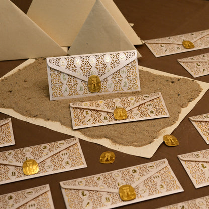 A styled ornate cream and gold patterned envelopes.