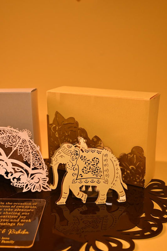 A premium dry fruit box crafted from 350 GSM board paper, adorned with two elephant cutouts and an umbrella.
An acrylic place mat that serves as the hamper's base and doubles as a stylish centerpiece for your table.
An acrylic name plate with personalized wishes.