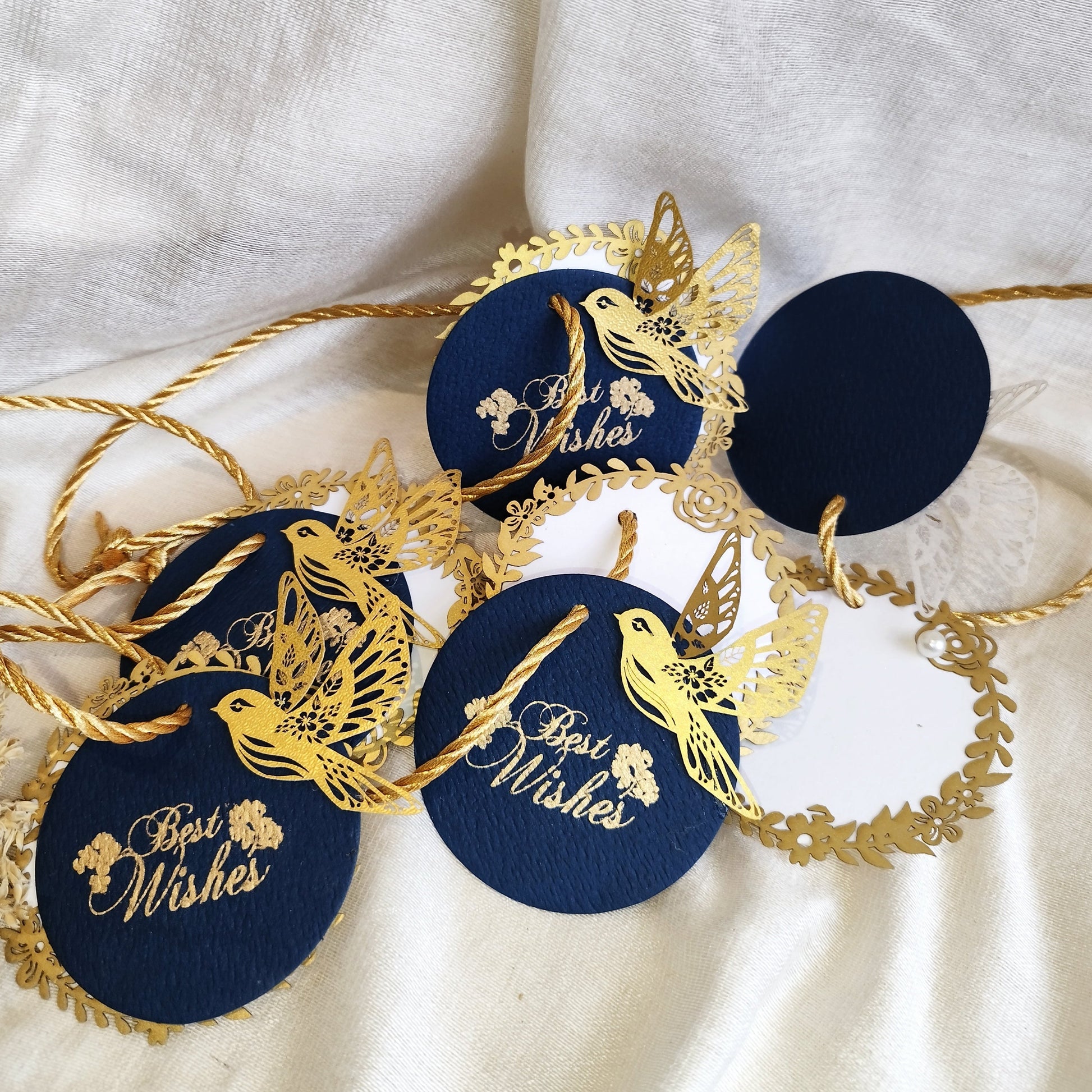 Layered blue gift tags with gold 'Best Wishes' text and gold bird cut-outs, in laser cut detailing