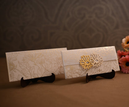 Two white embossed paper envelopes with gold floral patterns 
