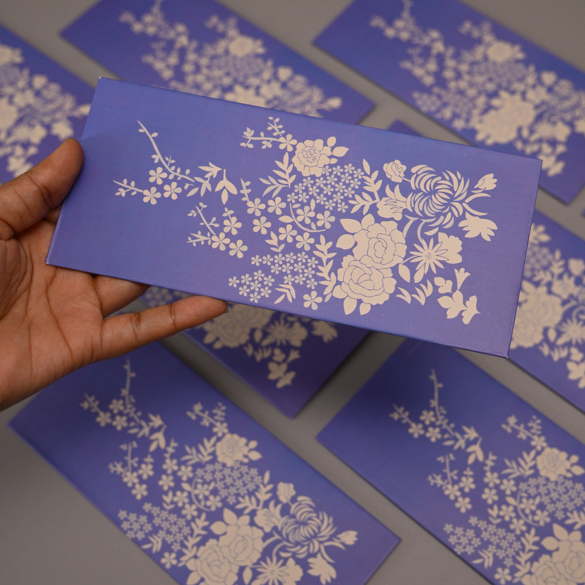 Lavender Envelope with a white floral pattern.