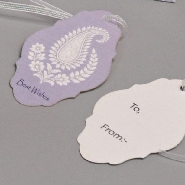  Gift tags with a white paisley floral design and the text 'Best Wishes,' on the back side white tag with 'To:' and 'From:' fields and a clear string.