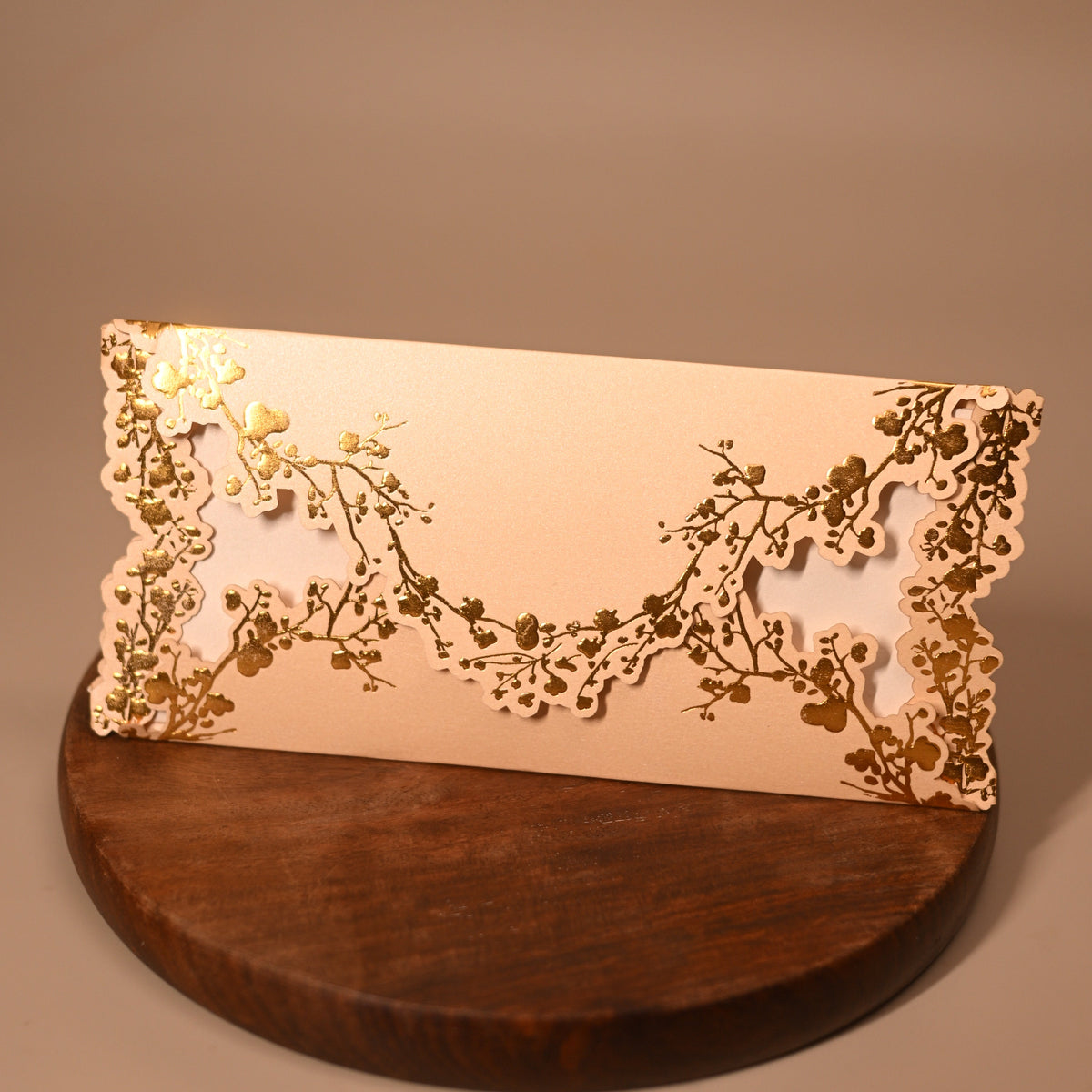 A rectangular cream-colored envelope or card with ornate laser-cut floral borders