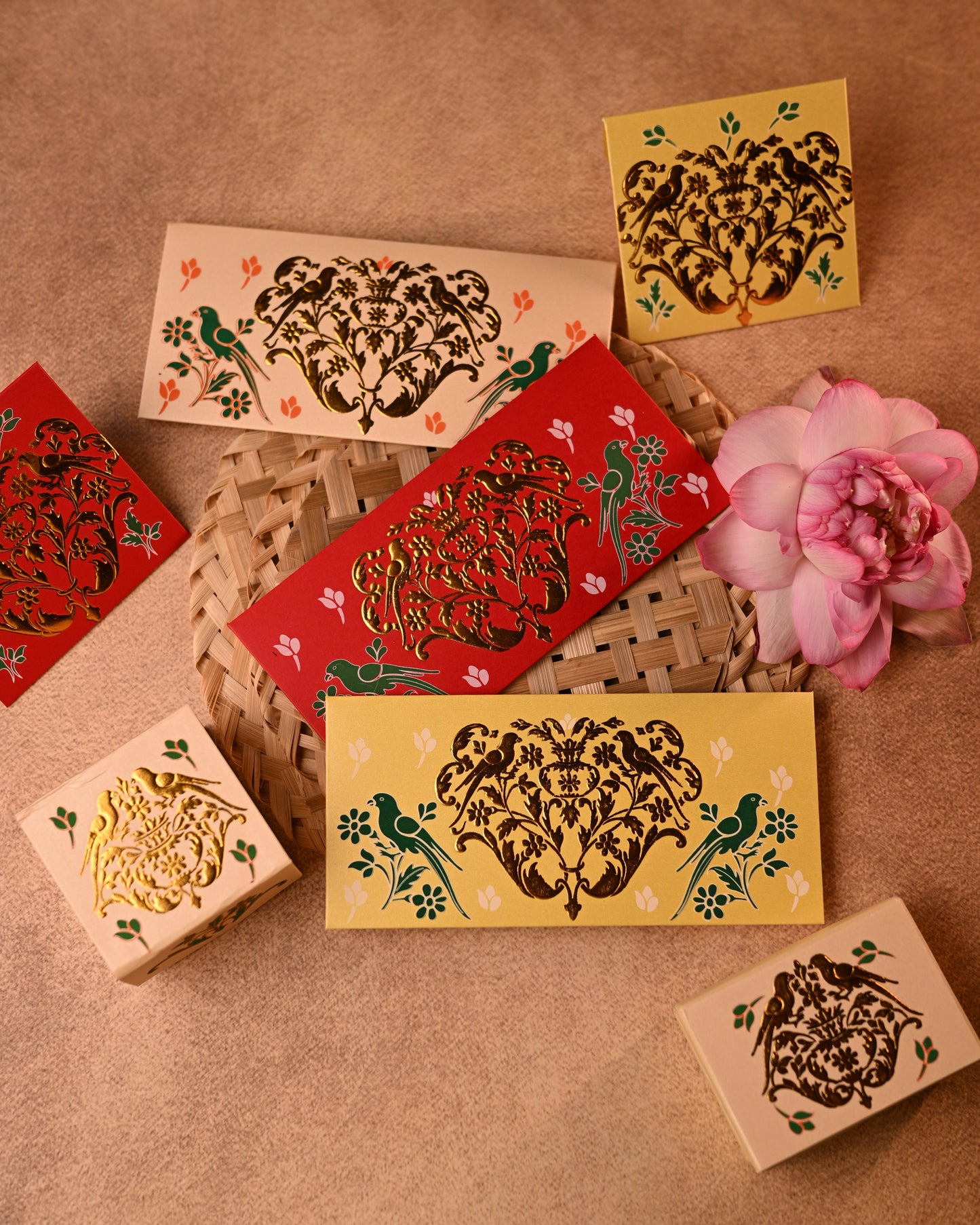 Decorative shagun envelopes with traditional gold parrot designs on a textured surface
