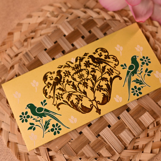 Decorative shagun envelopes with traditional gold parrot designs on a textured surface