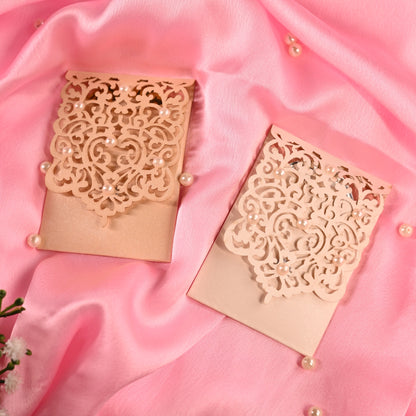 Two beige laser-cut lace envelopes with pearl accents