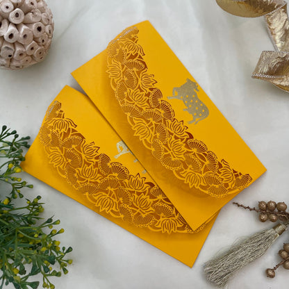 A set of two yellow envelopes inspired by pitchwai art with  a cow motif and a flap closure