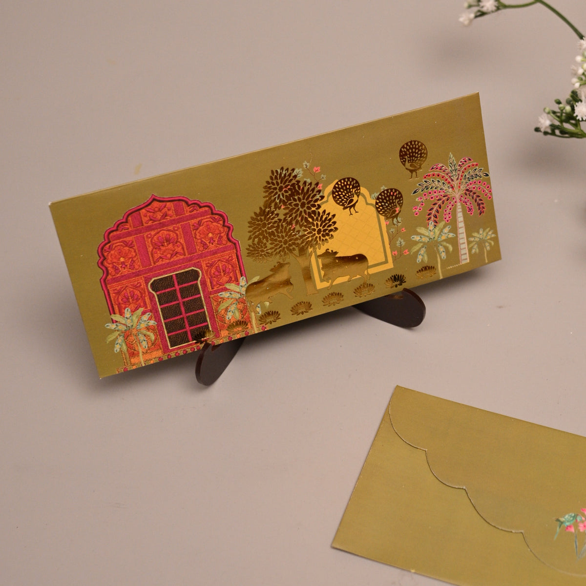 Envelope with a colorful printed design of a red house and Indian Pichwai themetheme