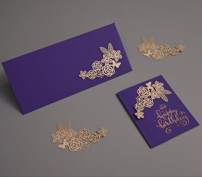 Purple stationery set with gold foil floral cutout details and gold script text reading 'Happy Birthday,' arranged on a gray background.