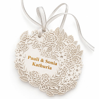 A personalized laser-cut wooden ornament with intricate floral lace patterns, hanging ribbons