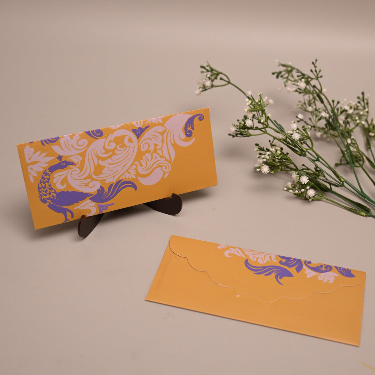 A yellow-green envelope with a purple and white ornate floral pattern