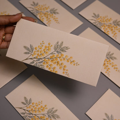 Envelope featuring a delicate yellow and gray botanical illustration of a flowering branch