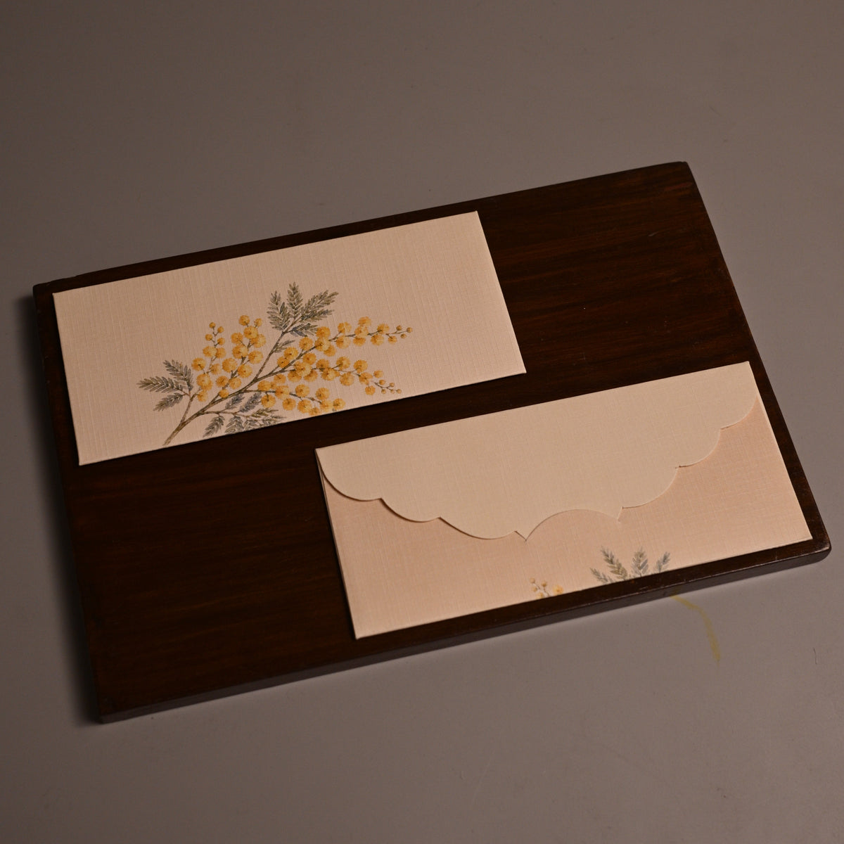 Envelope featuring yellow floral illustrations and scalloped cut edge.