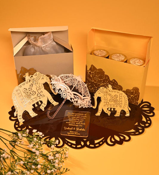 A premium dry fruit box crafted from 350 GSM board paper, adorned with two elephant cutouts and an umbrella.
An acrylic place mat that serves as the hamper's base and doubles as a stylish centerpiece for your table.
An acrylic name plate with personalized wishes.