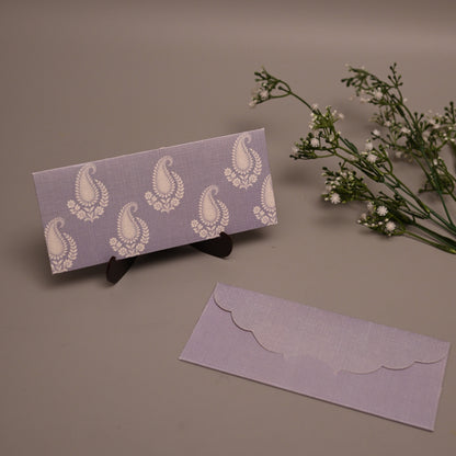 A lavender and white patterned envelope set displayed on a neutral background, featuring one envelope standing upright on a small black stand and another lying flat below it, with small white flowers to the right.