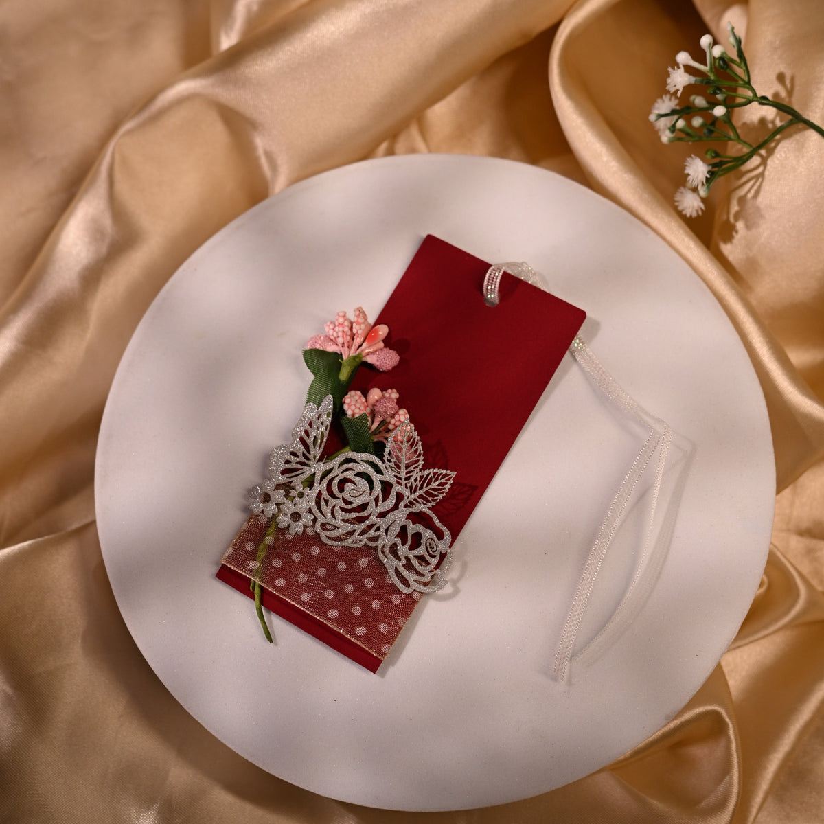 red gift tag with white ribbon and floral designs