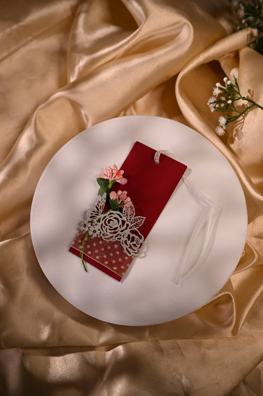 red gift tag with white ribbon and floral designs
