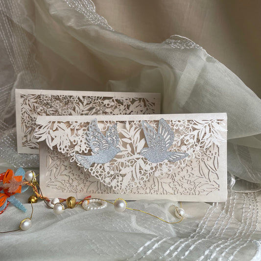 Decorative off white Envelope with intricate cut-out designs on an ivory metallic paper. Pair of birds pasted on its flap.