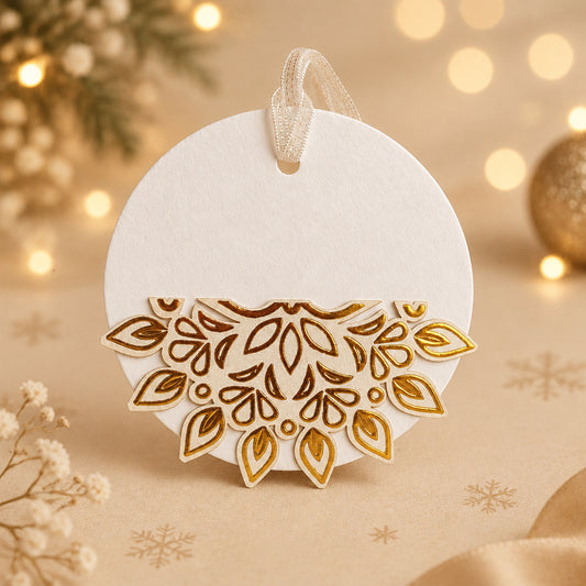 A half round gift tag with a golden foil embossing in a half-sun pattern design, attached to a white circular base with a ribbon.