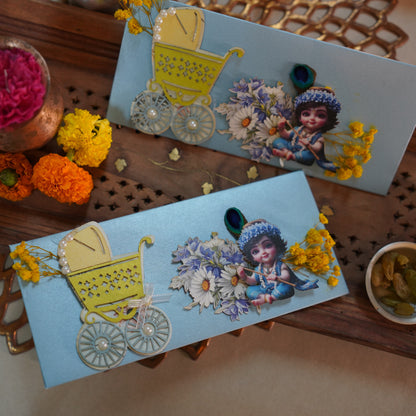 powder blue envelope showcasing a baby krishna, a pram and some flowers