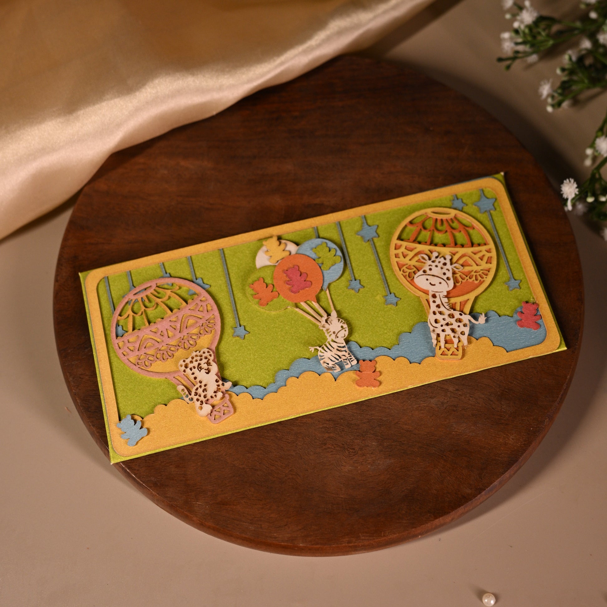 parachute  and animal envelopes on bright backgrounds and featuring intricate laser cut work.