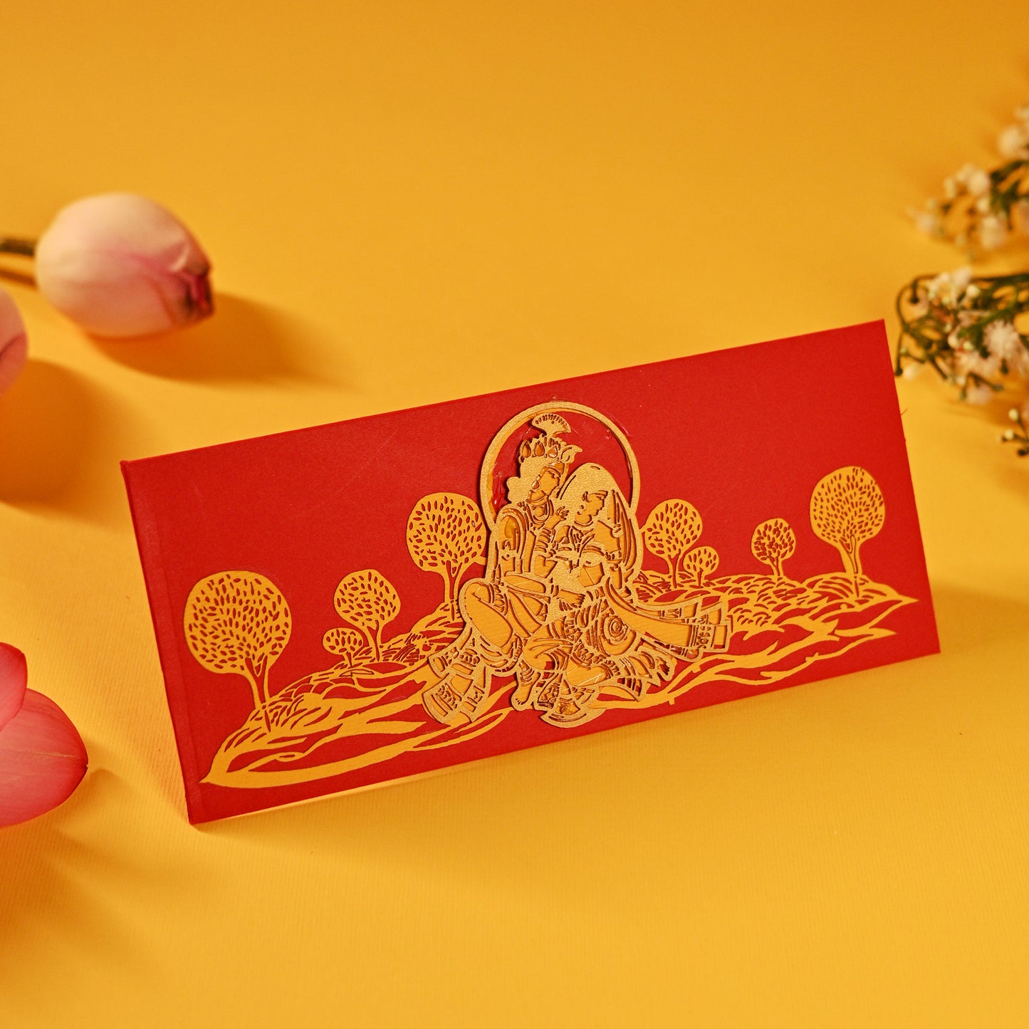 A set of laser-cut money envelopes with a Radha Krishna motif, in red, gold, and silver colours