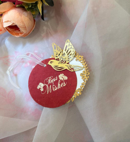 Layered red gift tags with gold 'Best Wishes' text and gold bird cut-outs, in laser cut detailing