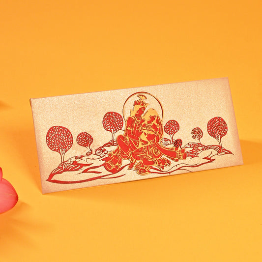 A set of laser-cut money envelopes with a Radha Krishna motif, in red, gold, and silver colours