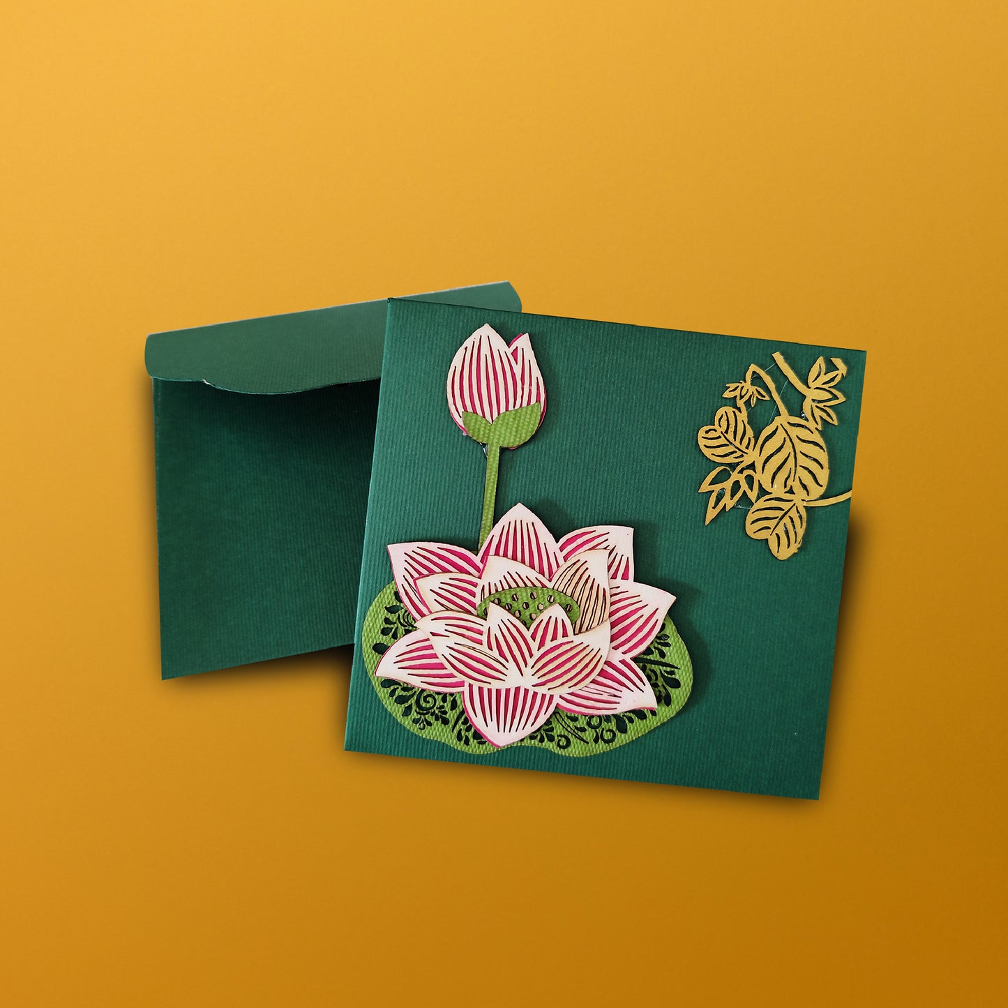 small green lotus envelope with laser-cut lotus work on one side and golden leaf motifs on the other