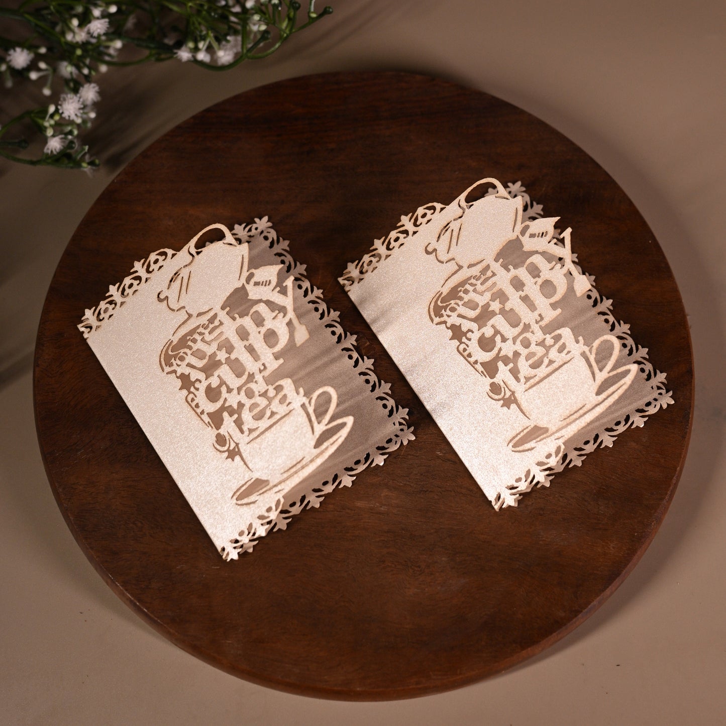 Decorative white gift tags with laser-cutwork, featuring a teapot, teacup and saucer, writing