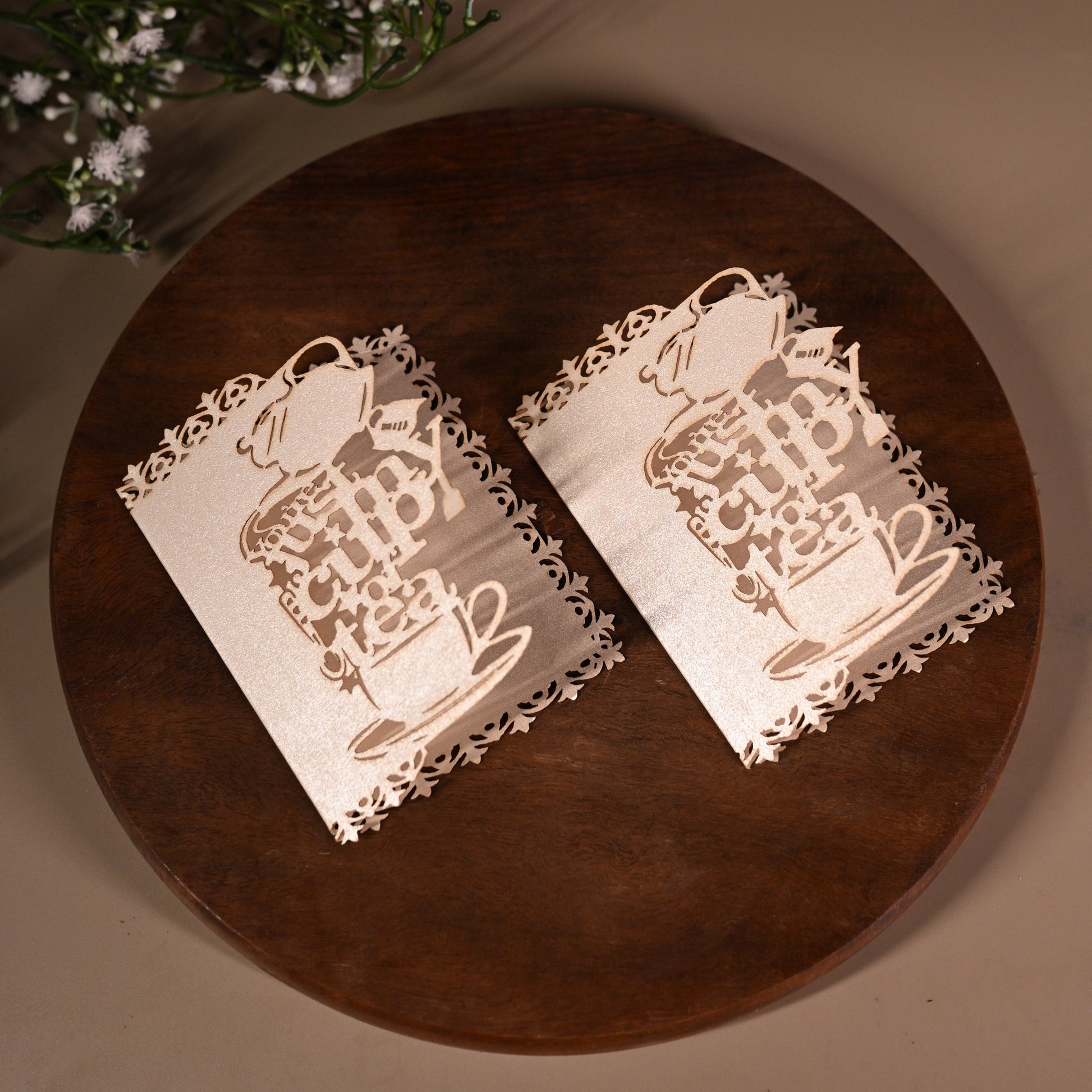 Decorative white gift tags with laser-cutwork, featuring a teapot, teacup and saucer, writing