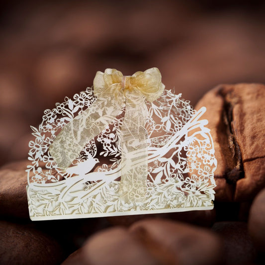 White full jali cashbox with intricate laser cut detailing of birds and nature, with a ribbon on top